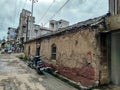 Stock photo of traditional clay made house with old damage clay made roof tile, cracks on mud wall and blue painted wooden door. Royalty Free Stock Photo