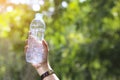 Stock Photo:Woman hand holding water bottle against green backg Royalty Free Stock Photo