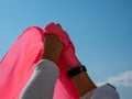 Woman holding a pink handkerchief with her hands up in the sky Royalty Free Stock Photo