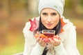 Stock Photo: Young attractive woman holding in hand hot red tea. Relaxing in autumn nature with hot tea