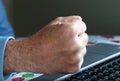 Stock Shot: Clenched, angry fist hits laptop computer keyboard Royalty Free Stock Photo