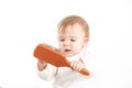 Studio photo with a white background of a baby with a comb in his hand