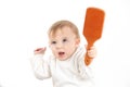 Studio photo with a white background of a baby with a comb in his hand