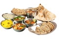 Stock of various indian food in metal bowls and on metal plates on white background