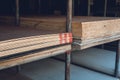 Stocked plywood sheets of differing thickness at an open-air hardware store