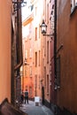 Stockholm narrow street. Orange, yellow houses and street lights. View from below of a cozy narrow medieval street