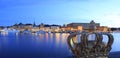 Stockholm`s Old Town Gamla Stan reflected into the lake at dusk with the royal crown on the foreground