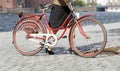 Woman leading red vintage bicycle ofer the cobble stone Royalty Free Stock Photo