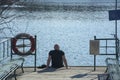 Man sitting dock lake spring sunshine Stockholm, Sweden