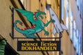 Old style metal science fiction book store sign of a dragon hold