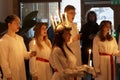 Lucia parade with singing girls and boys in white dresses holding candles. Traditional celebration of the suffering of saint