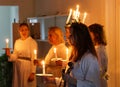 Lucia parade with singing girls and boys in white dresses holding candles. Traditional celebration of the suffering of saint Lucia