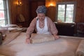 A woman making rustic thin bread with rolling pin, Skansen Open-Air Museum, Stockholm, Sweden