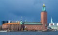 Stockholm, Sweden - 04.16.2017: Dramatic dark sky with clouds behind red brick building of City Hall, where Nobel Prize