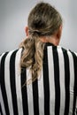 Back view of a male referee with ponytail hair. Royalty Free Stock Photo