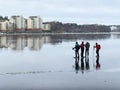 Beautiful winter scene with a group of ice skaters on wet ice in Stockholm. Royalty Free Stock Photo