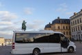Minibus on the background of the Statue of Charles XIV Johan in Stockholm on the square in
