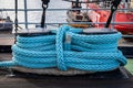Closeup horizontal view of a massive blue rope knot outdoor on deck.