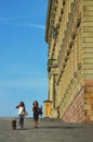 People walking by baroque style building of The Royal Palace in old town Gamla Stan, Stockholm, Sweden Royalty Free Stock Photo