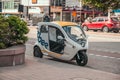 Stockholm, Sweden - June 7, 2019: White three wheeler commercial vehicle in the road. Rental motorbikes on parking