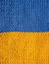 Stockinette stitch knitting in blue and yellow yarn