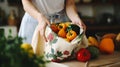 stockphoto, Female hands puts fruits and vegetables in cotton produce bag at food market. Reusable eco bag for shopping