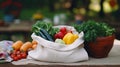 stockphoto, Female hands puts fruits and vegetables in cotton produce bag at food market. Reusable eco bag for shopping.