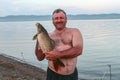 Stocky man with big carp. Khakassia