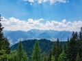 Stoderzinken - Majestic view of Dachstein mountain range framed by lush green alpine forests in Stoderzinken, Styria, Austria Royalty Free Stock Photo