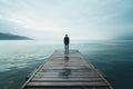 Stoic man on pier peers into vastness of distant ocean