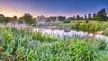 Misty dawn light on Stoke Charity village pond and St Michael`s Church, Hampshire, UK Royalty Free Stock Photo