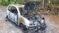 Stolen abandoned and burned out car in road forest Royalty Free Stock Photo