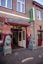 Entrance to chinese restaurant and take away with dragon statues at the door