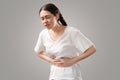 Stomach pain. Suffering young Caucasian woman holds her hands to her stomach. Menstruation and indigestion. The concept Royalty Free Stock Photo