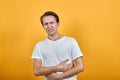 Stomach pains stomach problems white T-shirt young male on yellow background.