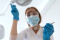 Stomatologist with dental instruments looking at camera