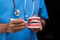 Stomatologist gives recommendations and shows the patient the procedure for dental treatment.