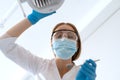 Stomatologist in mask and gloves preparing for patients teeth treatment