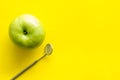 Stomatologist mirror and apple on yellow doctor`s office desk background top view mock-up Royalty Free Stock Photo