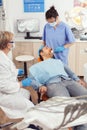 Stomatologist nurse looking in patient mouth preparing for dental surgery