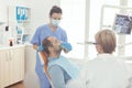 Stomatologist nurse putting oxigen mask to patient examining toothache