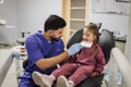 Stomatologist orthodontist male choosing selecting color of patient cute little preschool girl