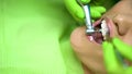 Stomatologist polishing female patients teeth, oral cavity protection, close up