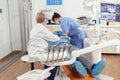 Stomatologist senior woman doing hygienic cleaning of teeth