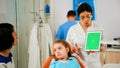 Stomatologist woman looking at green screen tablet while speaking with mother