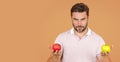 Stomatology concept. Man holding apple on beige studio isolated background. Man eat green apple. Close up portrait of Royalty Free Stock Photo