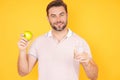 Stomatology concept. Man with perfect smile holding apple on studio isolated background. Man eat green apple. Portrait