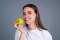 Stomatology concept. Woman with perfect smile holding apple on studio isolated background. Woman eat green apple Royalty Free Stock Photo