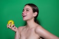 Stomatology concept. Woman with perfect smile holding apple on studio isolated background. Woman eat green apple Royalty Free Stock Photo