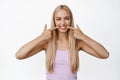 Stomatology and dental clinic concept. Beautiful blond girl showing her white smile, pointing fingers at teeth and Royalty Free Stock Photo